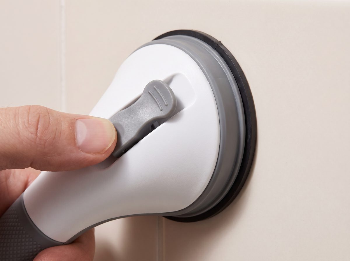 Close-up of a thumb flipping the lock-latch closed on a Mantle Grip suction pad